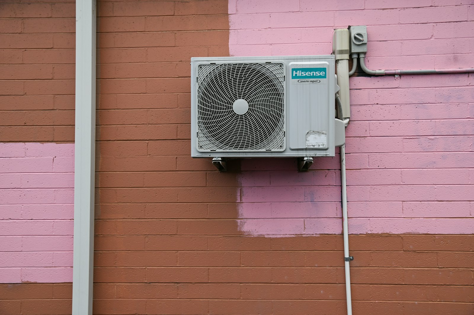 Outdoor mini-split condenser unit mounted on an exterior wall